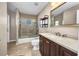 Bathroom featuring a tub shower, dark wooden vanity with a light countertop and decorative mirror at 4331 Marcella Ter, North Port, FL 34286