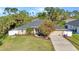 Lovely home featuring a green lawn, mature tree, well-placed plantings, and an attached two-car garage at 4331 Marcella Ter, North Port, FL 34286
