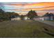 Charming single-story home with a well-manicured lawn and beautiful landscaping at sunset at 4331 Marcella Ter, North Port, FL 34286