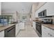 Open kitchen featuring stainless steel appliances, granite countertops, white cabinets, and tile floors at 4331 Marcella Ter, North Port, FL 34286