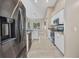 Galley kitchen with stainless steel appliances, granite countertops, white cabinets, and tile floors at 4331 Marcella Ter, North Port, FL 34286