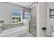 Bathroom featuring bathtub, separate glass shower, neutral walls, and tile floor at 4331 Marcella Ter, North Port, FL 34286