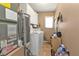 Well-equipped laundry room with washer, dryer, water heater and white cabinets at 4420 Larkspur Ct, Port Charlotte, FL 33948