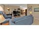 Cozy living room featuring comfortable blue sofas and open layout to dining area at 4420 Larkspur Ct, Port Charlotte, FL 33948