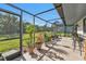 Spacious screened patio, featuring outdoor seating and lush green views at 4420 Larkspur Ct, Port Charlotte, FL 33948