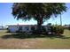 Features an inviting exterior, a well-manicured lawn, mature shade trees, and beautiful neutral color palette at 458 Azalea Nw Ave, Port Charlotte, FL 33952