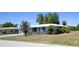 Features well-kept lawn, a vibrant blue door, and tasteful landscaping, set in a peaceful neighborhood at 458 Azalea Nw Ave, Port Charlotte, FL 33952