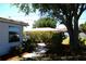 Quaint home exterior showcasing a well-maintained garden, mature tree, and a welcoming walkway at 458 Azalea Nw Ave, Port Charlotte, FL 33952