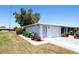 Features an attached garage with a brick driveway, side entry door, and neat, low-maintenance landscaping at 458 Azalea Nw Ave, Port Charlotte, FL 33952