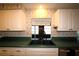 Kitchen sink with black faucet, white cabinets, green countertops, and window view at 458 Azalea Nw Ave, Port Charlotte, FL 33952