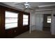 Cozy room featuring wood paneled walls, two windows, a ceiling fan and sliding glass doors at 458 Azalea Nw Ave, Port Charlotte, FL 33952