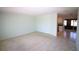 Spacious living room featuring neutral carpet, tile floors, and seamless access to the kitchen area at 458 Azalea Nw Ave, Port Charlotte, FL 33952