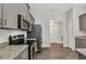 Well-lit kitchen with stainless appliances, granite countertops and grey cabinetry, open to the rest of the home at 474 Rio De Janeiro Ave, Punta Gorda, FL 33983