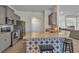 Kitchen island with barstool seating, stainless appliances and granite countertops, opening into living area at 474 Rio De Janeiro Ave, Punta Gorda, FL 33983