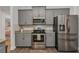 Modern kitchen features stainless steel appliances, gray cabinets, and granite countertops at 474 Rio De Janeiro Ave, Punta Gorda, FL 33983