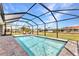 Sparkling screened-in pool features brick pavers and view of the manicured backyard at 474 Rio De Janeiro Ave, Punta Gorda, FL 33983
