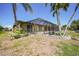 Backyard with enclosed pool, landscaping and canal view with palm trees at 490 Via Esplanade, Punta Gorda, FL 33950