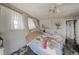 Bedroom featuring a ceiling fan, a dresser, and a large window, with signs of water damage throughout the room at 490 Via Esplanade, Punta Gorda, FL 33950