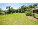 Well-manicured backyard featuring a lush lawn, mature trees, and a view of the waterfront at 552 Mccabe St, Port Charlotte, FL 33953