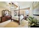 Elegant bedroom with a canopy bed, ceiling fan, and a classic wood dresser at 552 Mccabe St, Port Charlotte, FL 33953