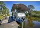 Canal-front home featuring boat lift with a covered canopy, dock and space for potted plants at 552 Mccabe St, Port Charlotte, FL 33953