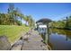 A long dock on the canal has a boat lift with seating for relaxing by the water at 552 Mccabe St, Port Charlotte, FL 33953