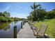 Wooden dock features chairs and a view of the water and lush greenery at 552 Mccabe St, Port Charlotte, FL 33953