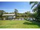 Waterfront property features a boat dock, lift, and seating area on a canal with a lush lawn at 552 Mccabe St, Port Charlotte, FL 33953