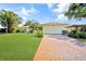 Inviting single-story home with a lush green lawn and mature landscaping at 552 Mccabe St, Port Charlotte, FL 33953