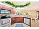 Well-lit kitchen offering stainless steel appliances, wood cabinets and granite countertops at 552 Mccabe St, Port Charlotte, FL 33953