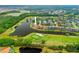 Aerial view of a lakeside home in a golf community, showcasing lush landscaping and water views at 624 Planters Manor Way, Bradenton, FL 34212