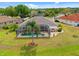Aerial view of backyard featuring a screened-in pool, spa, palm tree, and well-maintained lawn at 624 Planters Manor Way, Bradenton, FL 34212