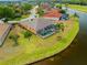Aerial view showing backyard with pool and spa, adjacent to waterfront with lush landscaping at 624 Planters Manor Way, Bradenton, FL 34212