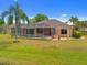 Exterior view of backyard featuring screened-in pool and mature landscaping at 624 Planters Manor Way, Bradenton, FL 34212
