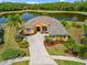 Beautiful house with manicured lawn, mature trees, and serene lake view, creating a peaceful and inviting atmosphere at 624 Planters Manor Way, Bradenton, FL 34212