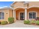 Grand entrance with custom double doors, elegant columns, and lush landscaping, creating a welcoming ambiance at 624 Planters Manor Way, Bradenton, FL 34212