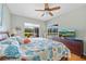 Sunlit main bedroom with wood floors and peaceful views of the lake and pool area at 624 Planters Manor Way, Bradenton, FL 34212