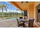 Covered patio area with dining set and scenic views of the pool and pond at 624 Planters Manor Way, Bradenton, FL 34212