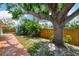A spacious backyard with a mature tree, brick paver patio and a wood fence offering privacy at 1137 Ponderosa Rd, Venice, FL 34293