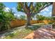 Fenced backyard with patio, lush greenery, providing private outdoor space and shade at 1137 Ponderosa Rd, Venice, FL 34293