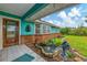 Charming turquoise home featuring a welcoming front porch and an attractive decorative fountain at 1137 Ponderosa Rd, Venice, FL 34293