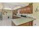 Long kitchen counter space with wood cabinets, decorative backsplash, and white tile flooring at 1137 Ponderosa Rd, Venice, FL 34293