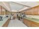 Open kitchen features stainless steel appliances, wood cabinets, countertops, and tile flooring at 1137 Ponderosa Rd, Venice, FL 34293