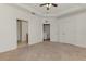 A bedroom showing multiple doors, neutral carpeting, and a ceiling fan at 1156 Jonah Dr, North Port, FL 34289
