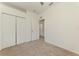 Clean bedroom featuring neutral carpet, a ceiling fan, and doors to closet and hallway at 1156 Jonah Dr, North Port, FL 34289