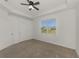 Spacious bedroom featuring neutral carpeting, bright white walls, and a window with outside views at 1156 Jonah Dr, North Port, FL 34289