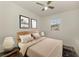 Cozy bedroom with neutral carpet, ceiling fan, and large window letting in natural light at 1156 Jonah Dr, North Port, FL 34289