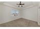 Neutral-toned bedroom with tray ceiling and ceiling fan and neighborhood views at 1156 Jonah Dr, North Port, FL 34289