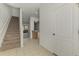 View of home's entrance featuring tiled floors, carpeted stairs, a white door, and a glimpse into the kitchen at 1156 Jonah Dr, North Port, FL 34289