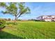 Exterior view of the property showcasing lush green space and community buildings in the background at 1156 Jonah Dr, North Port, FL 34289